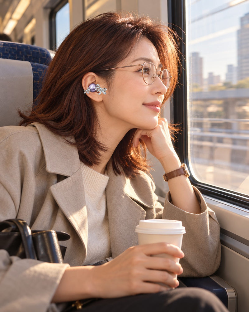 Woman with glasses on a train wearing a lavender bow clip-on earbud